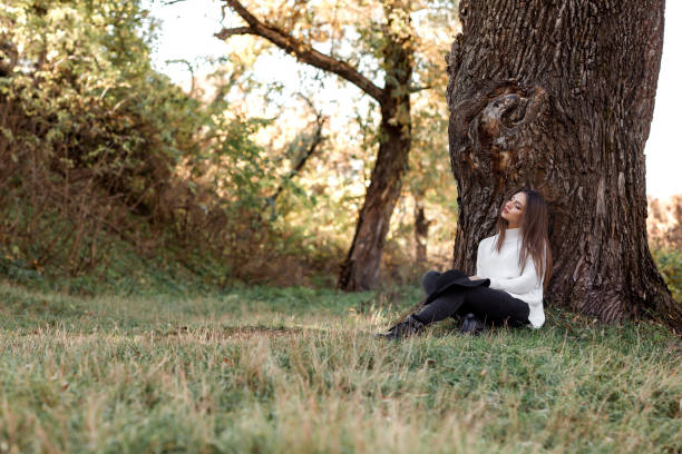 istock beautiful woman in black hat sitting under big tree 1068461450