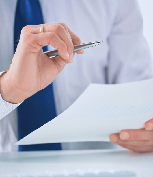 istock Serious business man working on documents and makes notes with a pen close-up. 1068464688