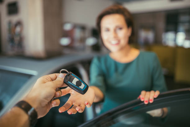 husband giving the car keys from new car to his wife - car test drive car rental women imagens e fotografias de stock