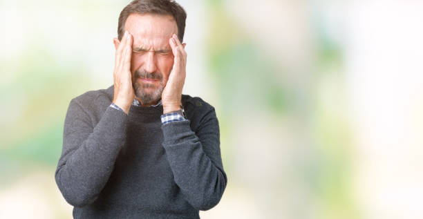 istock Handsome middle age senior man wearing a sweater over isolated background with hand on head for pain in head because stress. Suffering migraine. 1068468018