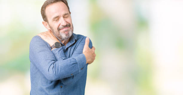 istock Handsome middle age elegant senior man over isolated background Hugging oneself happy and positive, smiling confident. Self love and self care 1068468240