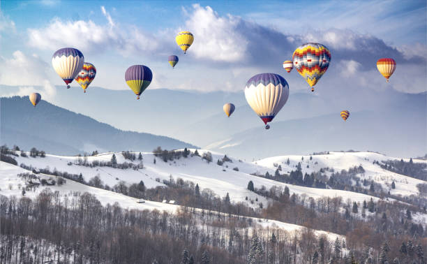 Multicolored hot air balloons on a mountain ridge covered snow stock photo