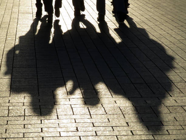 People silhouettes and shadows on the street Crowd walking down on sidewalk, concept of strangers, crime, society, urbanisation, city life gang photos stock pictures, royalty-free photos & images
