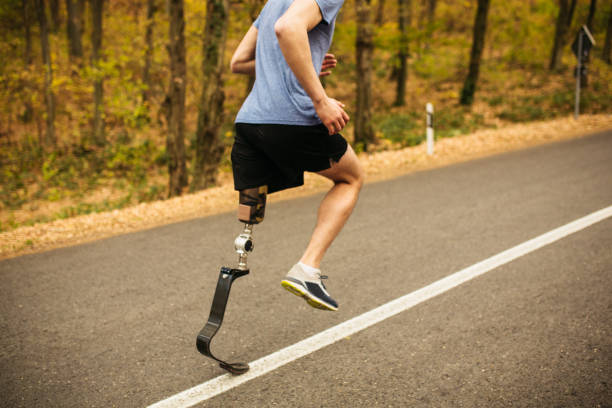 istock Young men with prosthetic legs running uphill in the forrest 1068486526