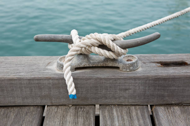 istock Anchored white rope on dock by water 1068496020