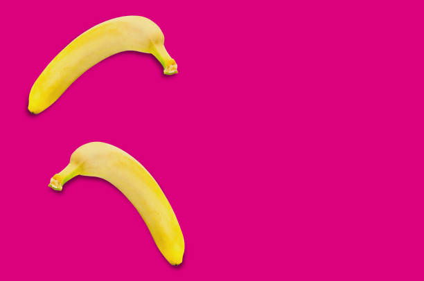 istock Two fresh whole ripe bananas on pink background with copy space for your text 1068505074