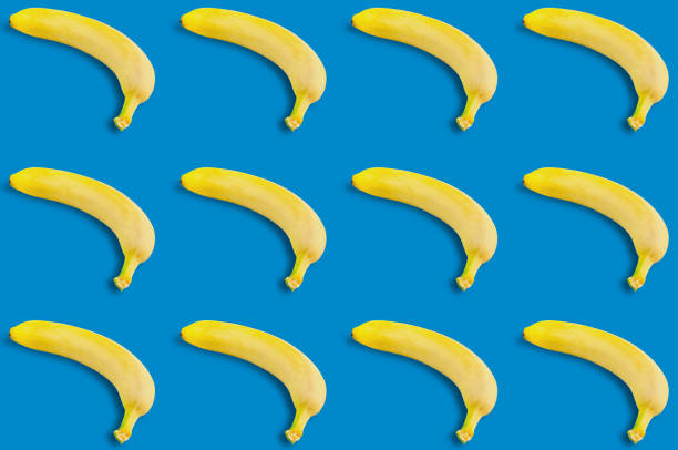 istock Rows of many fresh whole ripe bananas on blue background. Seamless pattern 1068505082