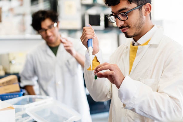 Multi-ethnic professor and student in college science laboratory.