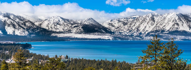 View towards Lake Tahoe on a sunny clear day Panoramic view towards Lake Tahoe on a sunny clear day; the snow covered Sierra mountains in the background; evergreen forests in the foreground sierra stock pictures, royalty-free photos & images