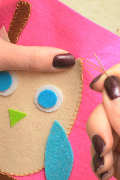 istock Sewing application of a owl of felt with a thread and a needle 1068538012