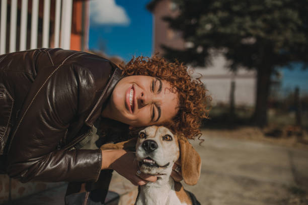 istock Girl playing with her beagle dog 1068540630