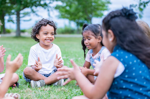 istock Children sitting on the grass in a park 1068540832