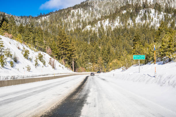 conduisant sur une route couverte de neige et de glace - carson nevada city valley photos et images de collection