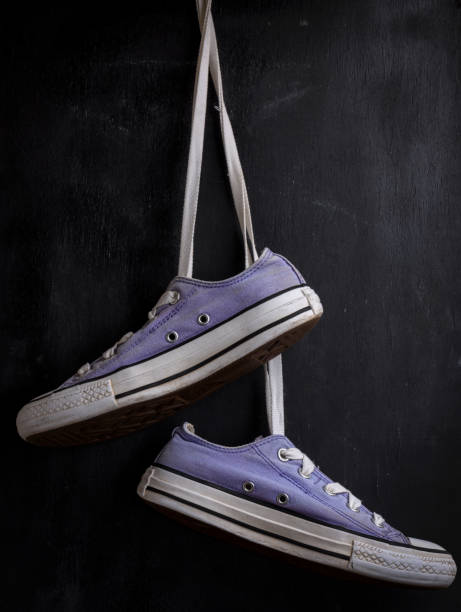 purple textile sneakers hanging on a lace