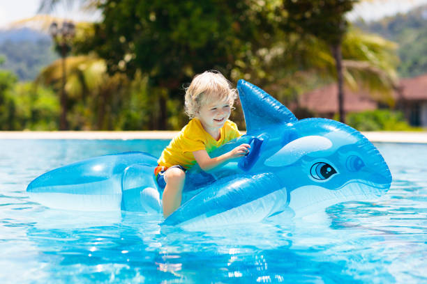 Child in swimming pool. Kid on inflatable float