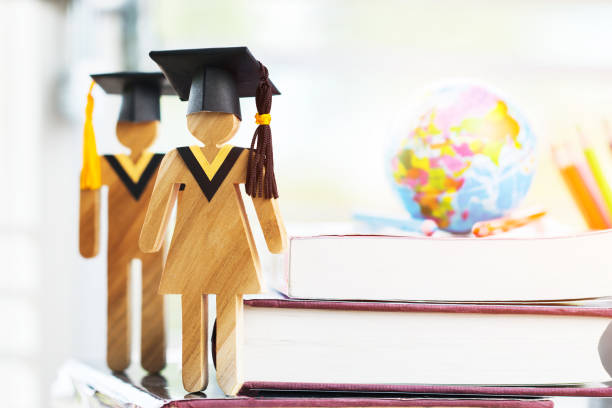 istock Education knowledge learning study abroad international Ideas. People Sign wood with Graduation celebrating cap on open textbook, Europe global map show alternative studying Back to School Concept 1068584956