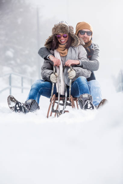 istock Beautiful couple with sled outdoors in snow 1068590512