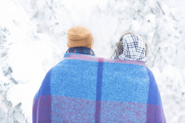 istock Young couple in snow outdoors with blanket 1068590560