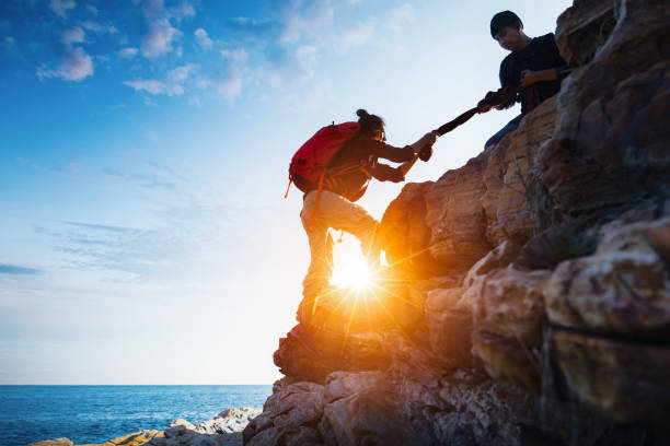 istock Young asian couple climbing up on the mountain 1068594086