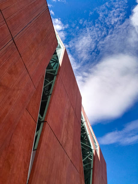 istock Modern, futuristic and bold architecture building with red features and blue sky 1068597114