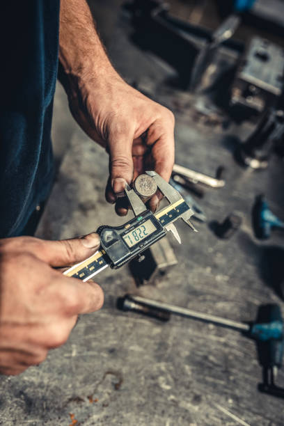 Technician in a Metal Manufacturing Company Measuring with Digital Vernier Caliper - fotografia de stock