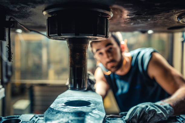 Worker Installing Tool on Machine in Factory - fotografia de stock