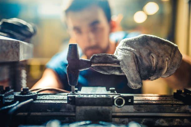 Worker Installing Tool on Machine in Factory - fotografia de stock