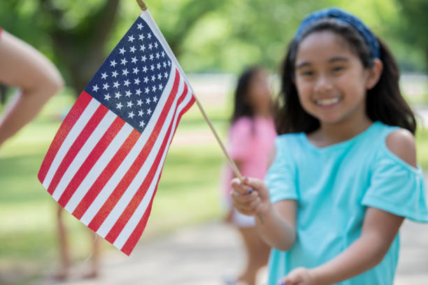 focus selettivo della bandiera americana detenuta dallo studente delle scuole elementari asiatiche - child flag fourth of july little girls foto e immagini stock