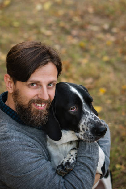 istock Man and dog in autumn park 1068603784