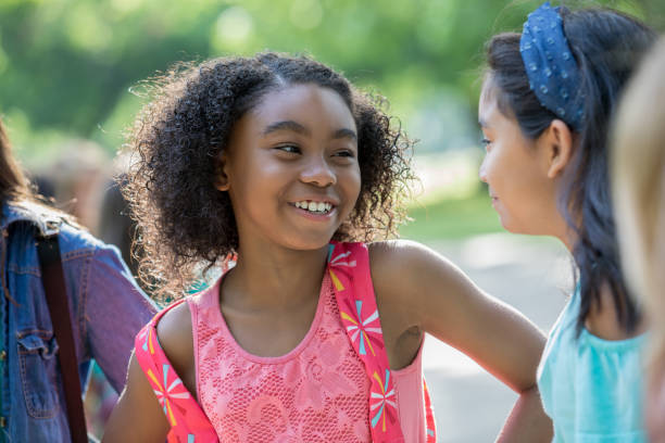 istock Cute African American elementary student laughing with friend outside school 1068605956
