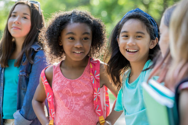 istock Diverse elementary school classmates waiting outside school together 1068605960