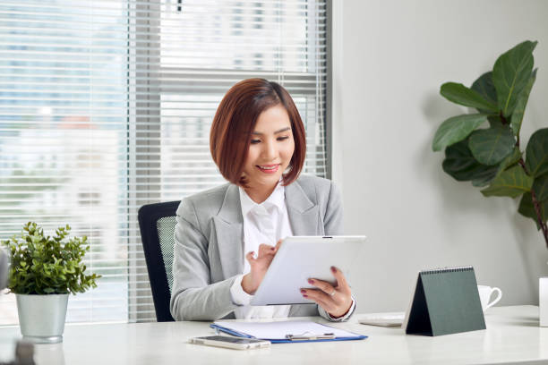 istock Asian businesswoman working with tablet computer at office desk. 1068613384