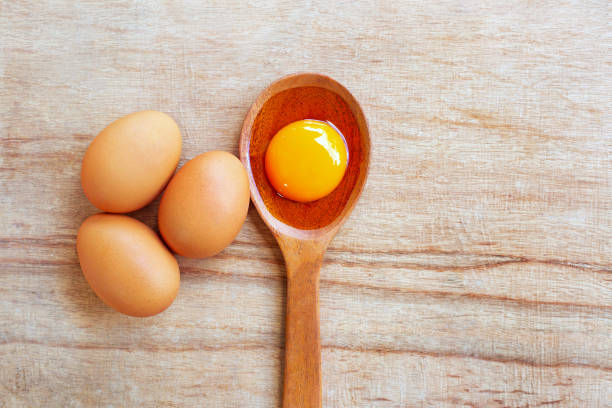 istock Egg yolk on wooden spoon, Wooden background. 1068620198