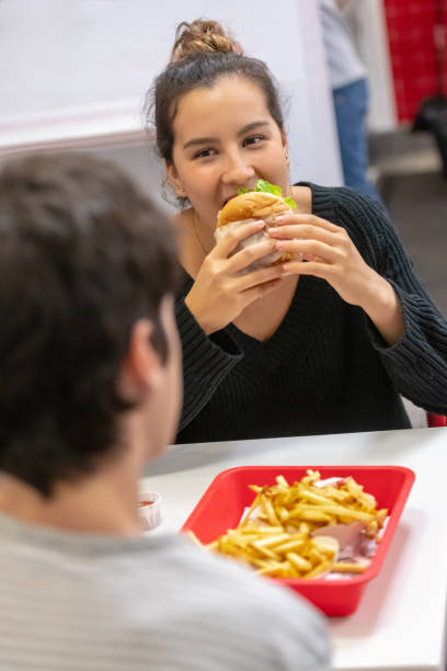 istock Young couple having a hamburger at a fast food place 1068622830