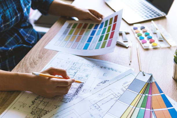 istock Creative designer graphic working with choosing color samples swatch for building plans in office. Graphic and construction concept. 1068624250