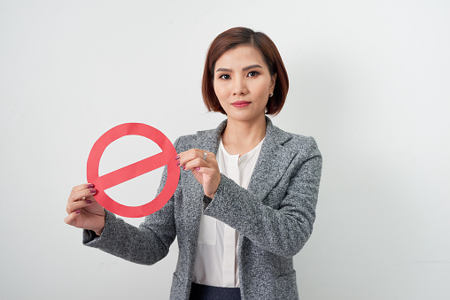 A businesswoman holding a with stop symbol isolated on white background