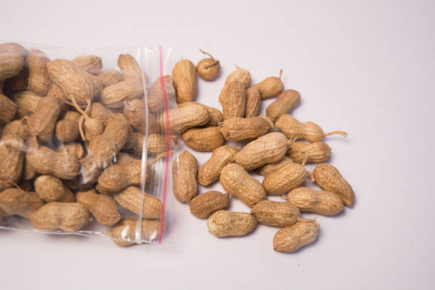 istock Groundnuts or Peanuts coming out of the plastic bag on isolated background 1068625870