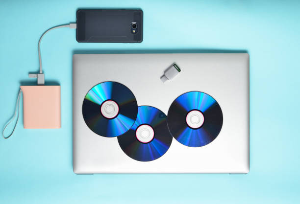 istock Laptop, smartphone, power bank, CD drives, USB flash drive on a blue background. Modern and outdated digital media and gadgets. 1068626268