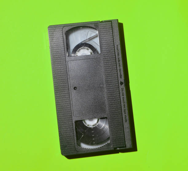 istock Retro videocassette from 80s on a green background. Obsolete media technologies. 1068627630