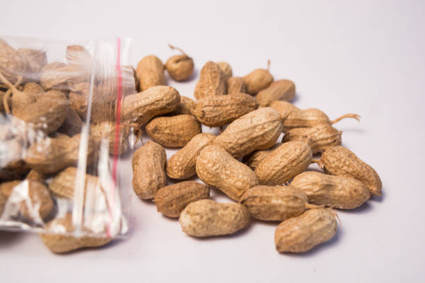 istock Groundnuts or Peanuts coming out of the plastic bag on isolated background 1068628284