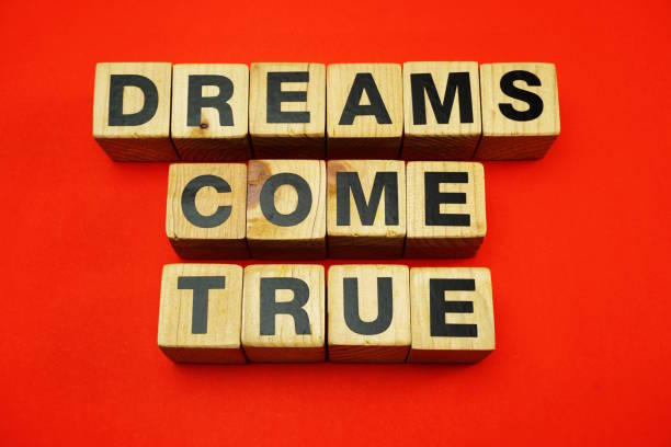 istock dream come true word created with cubes alphabet letters on red background 1068631490