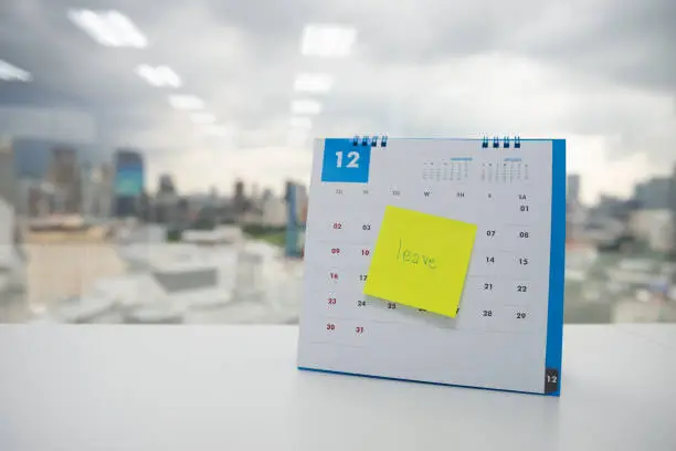 Photo of Leave on paper note stick on the calendar of December for year end holidays concept