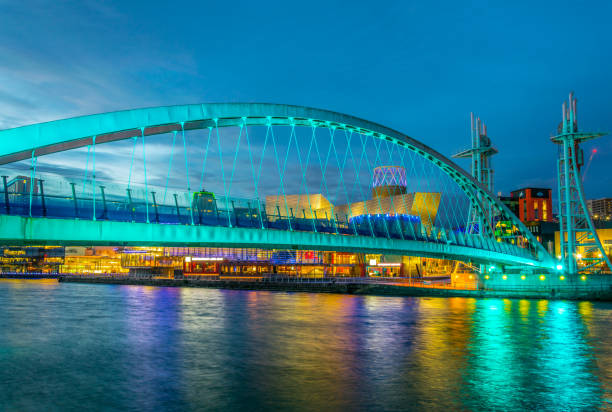 blick auf einen beleuchteten steg in salford quays in nacht in manchester, england - millennium footbridge stock-fotos und bilder