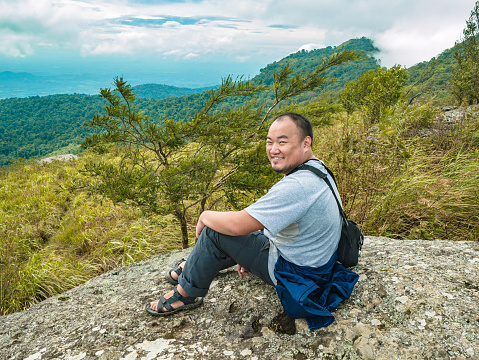 Asian Fat Trekker sit on the stone at Khao Luang mountain  in Ramkhamhaeng National Park,Sukhothai province Thailand