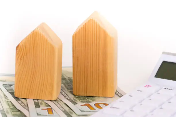 wooden house model with dollars banknotes, real estate concept