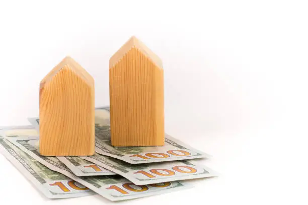 wooden house model with dollars banknotes, realty expensive cost concept