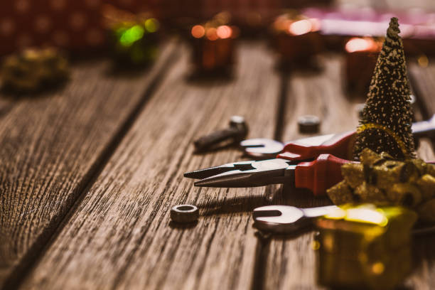 Handy Tools Christmas background concept.  Pliers and wrenches with Christmas ornament decoration on a rustic wooden table.