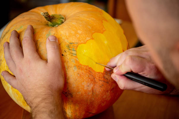 istock man carving on a pumpkin 1068662890