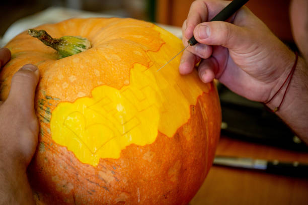 istock man carving on a pumpkin 1068662942