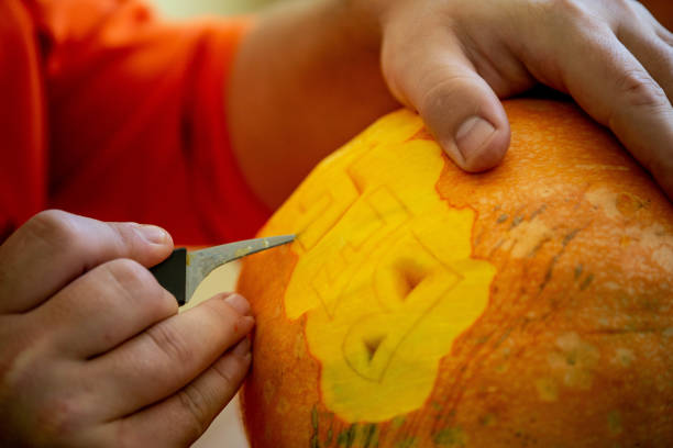 istock man carving on a pumpkin 1068662978